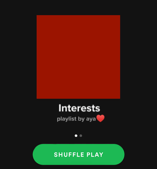 A thumbnail of solid dark red captioned "Interests, playlist by aya(heart emoji)". There's a green shuffle button under it.